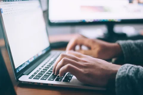 Person typing on a Mac laptop