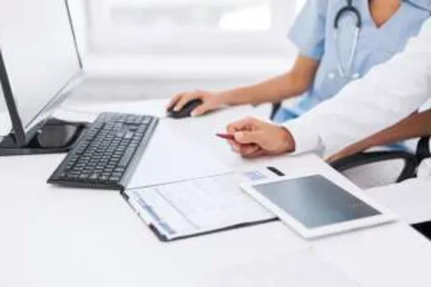 Professionals sitting by computer and tablet
