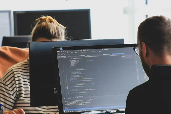 Two people sitting in front of their computers