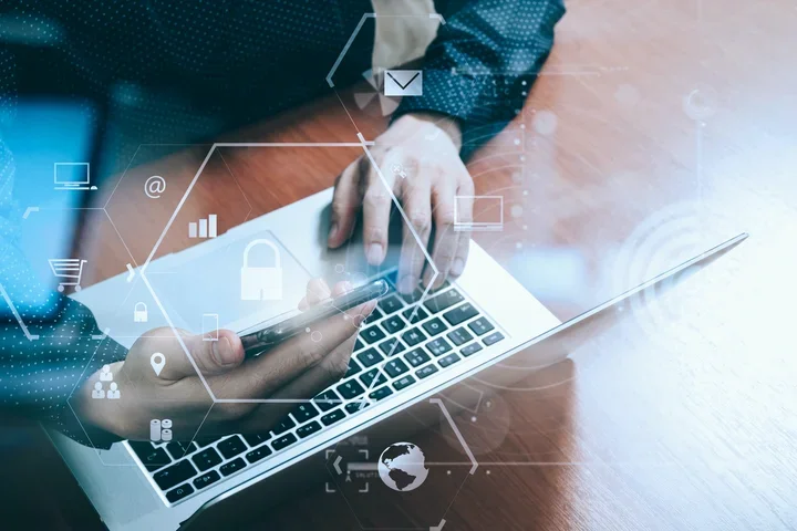 Person on a laptop with security icons 