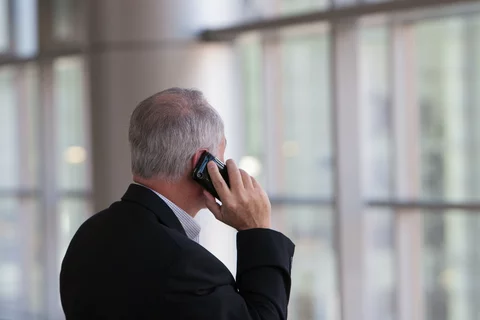 Man standing in front of a window on a phone call