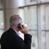Man standing in front of a window on a phone call